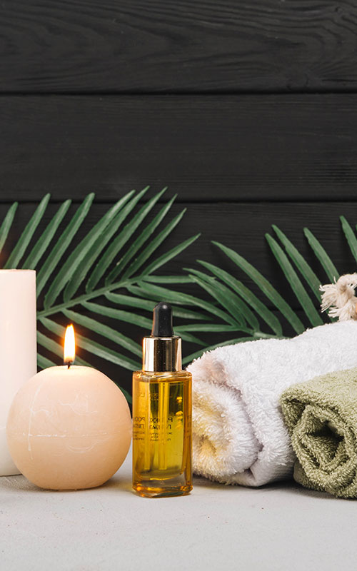 towels candles and golden bottle of body oil